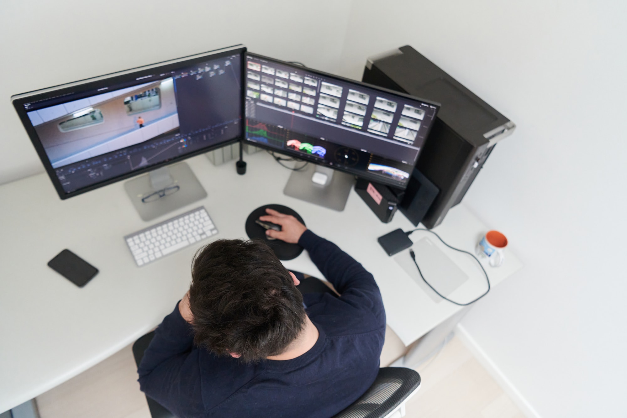 Post-production — video editor grading footage in a multi-monitor suite